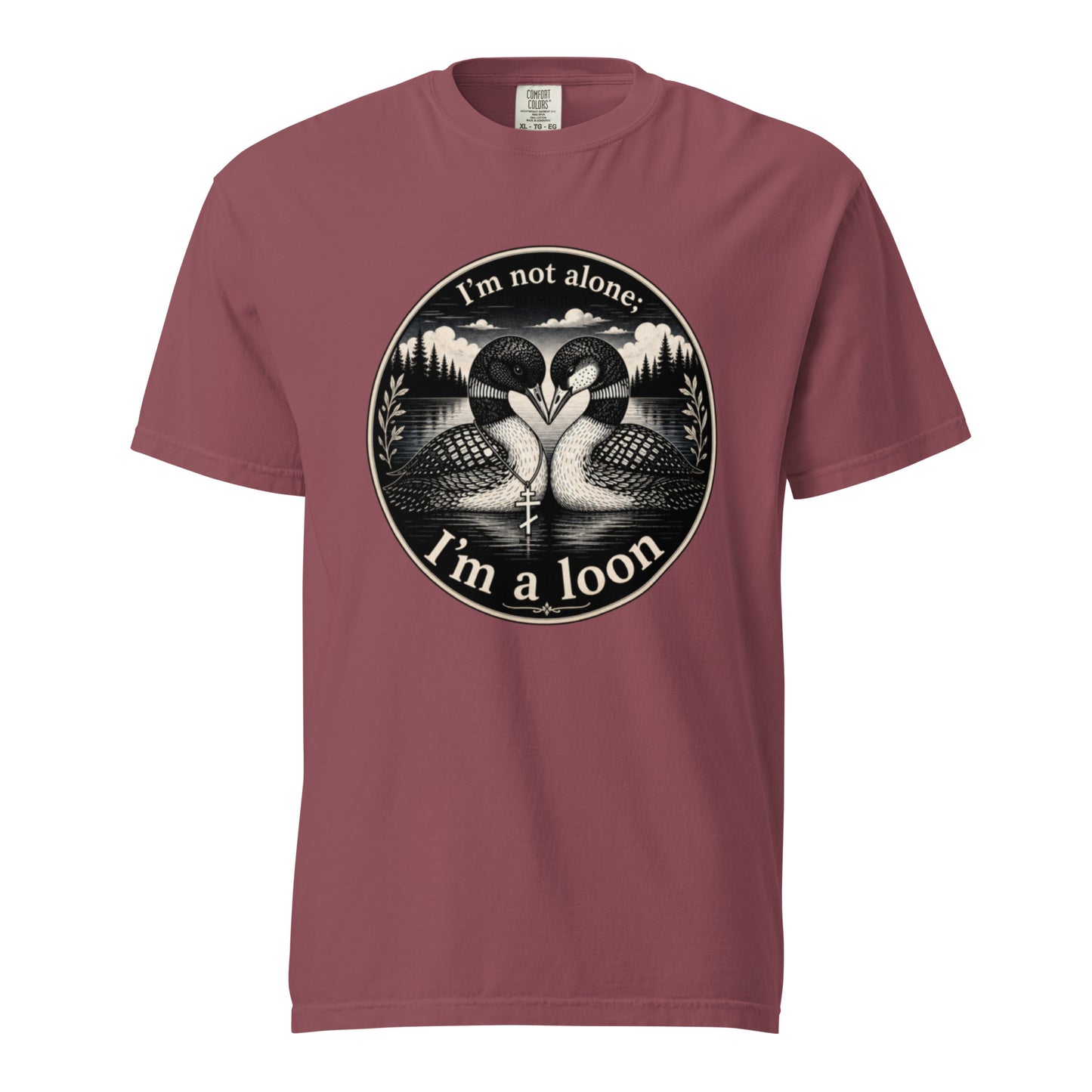 A Brick colored short-sleeve crewneck t-shirt featuring a circular black and white graphic of two loons facing each other in front of a lake and mountains, with the text 'I'm not alone. I'm a loon.'
