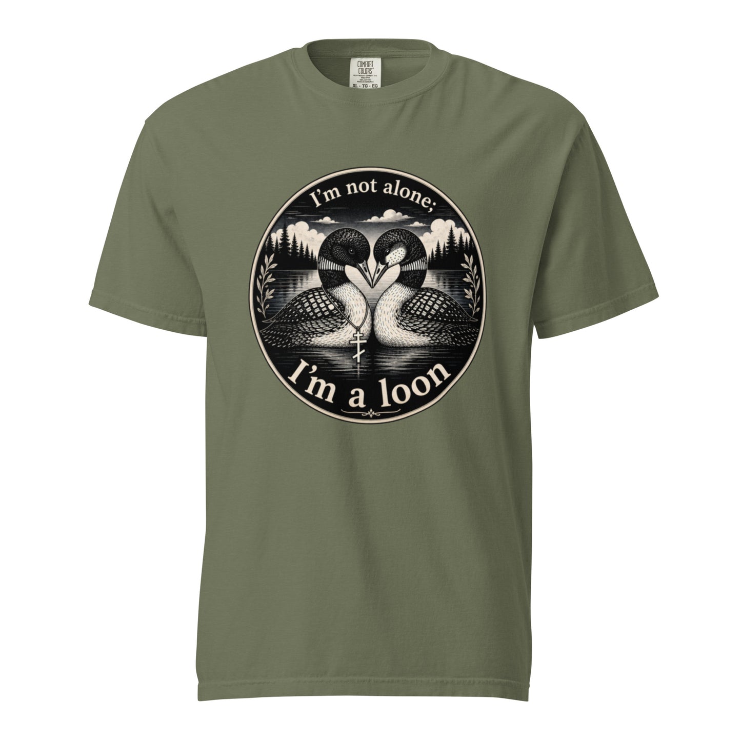 A Moss colored short-sleeve crewneck t-shirt featuring a circular black and white graphic of two loons facing each other in front of a lake and mountains, with the text 'I'm not alone. I'm a loon'.