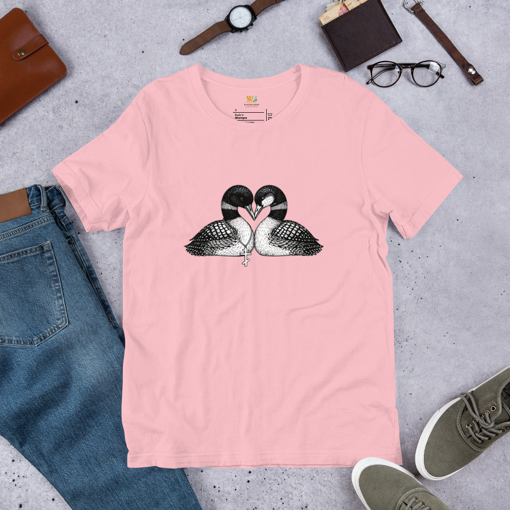 Pink hockey romance loon t-shirt with a black and white graphic of 2 loons with beaks together forming a heart, one loon wears a Russian orthodox cross around it's neck, the other loon has freckles on it's face.