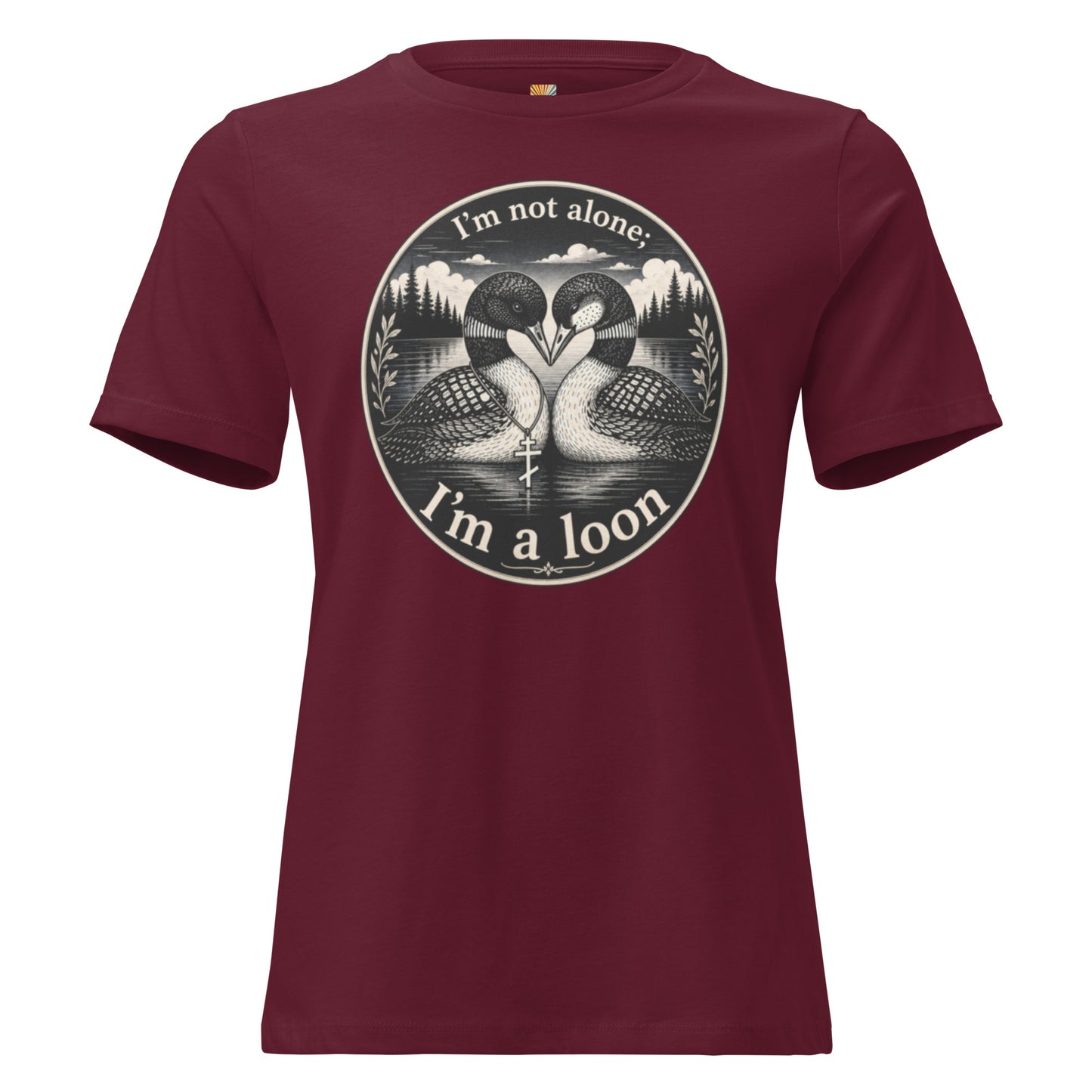 A graphic tee for women in maroon, short-sleeved crewneck featuring a circular graphic print of two loons in a lake with the text 'I'm not alone; I'm a loon' in white.