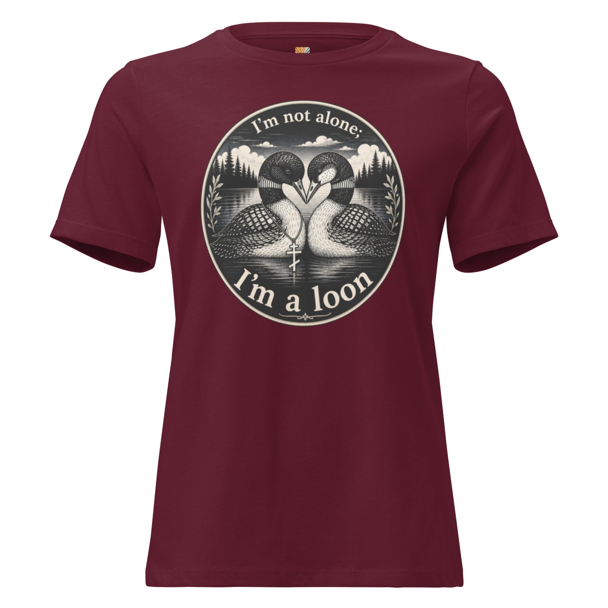 A graphic tee for women in maroon, short-sleeved crewneck featuring a circular graphic print of two loons in a lake with the text 'I'm not alone; I'm a loon' in white.