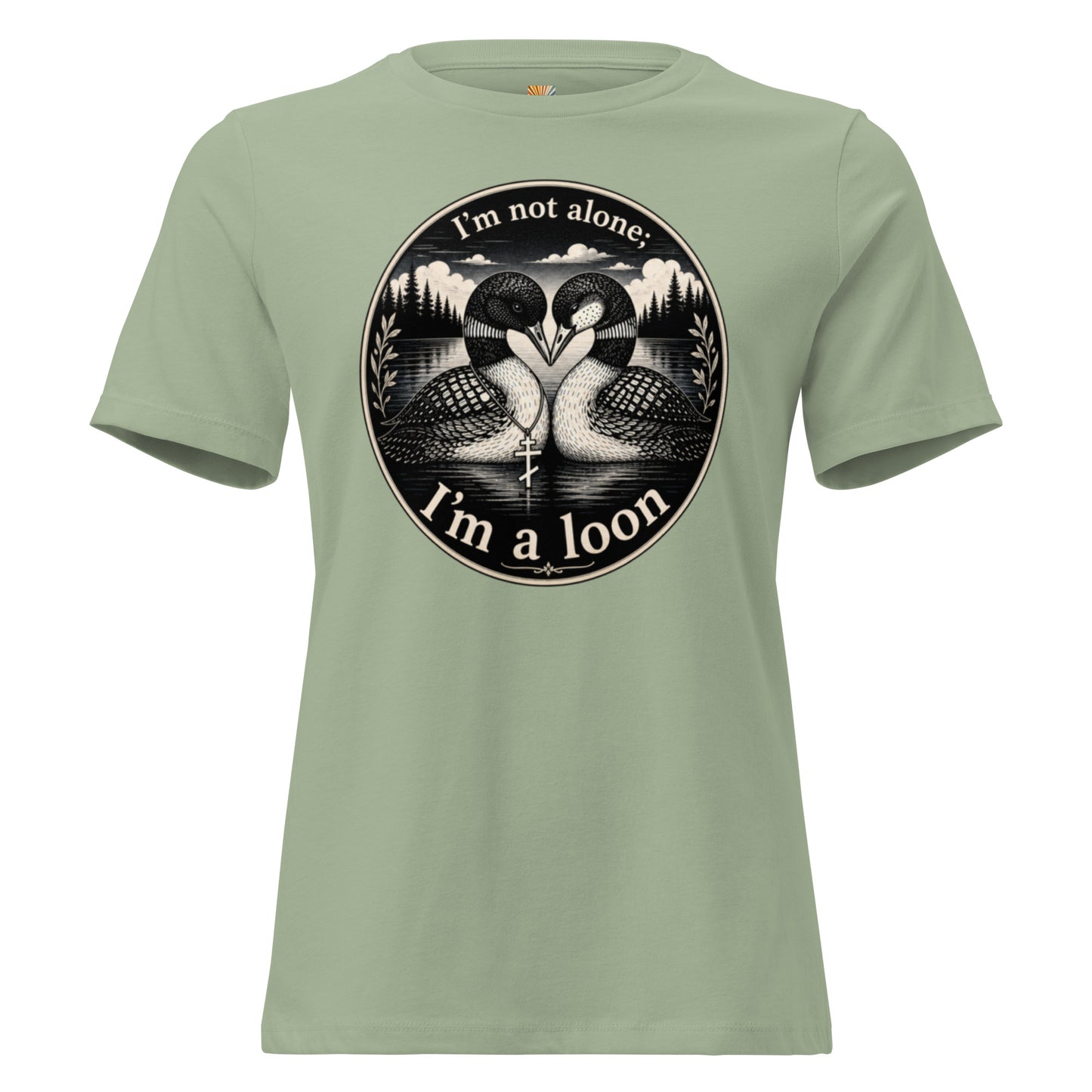 A graphic tee for women in sage green, short-sleeved shirt with a circular black and white graphic on the chest showing two loons and the text 'I'm not alone; I'm a loon'.